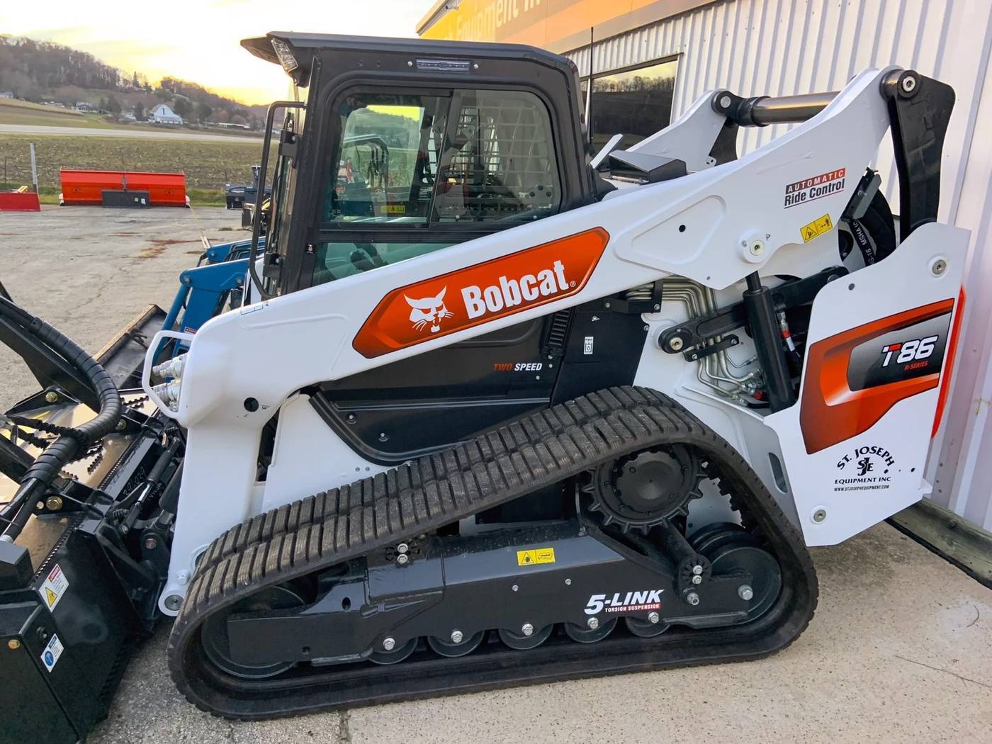 Compact track loader parked on a gravel yard